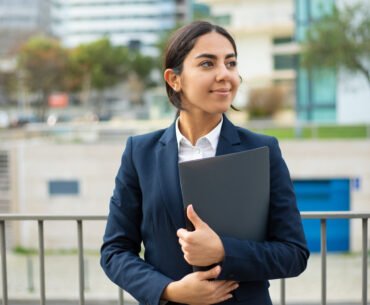 happy businesswoman holding folder scaled